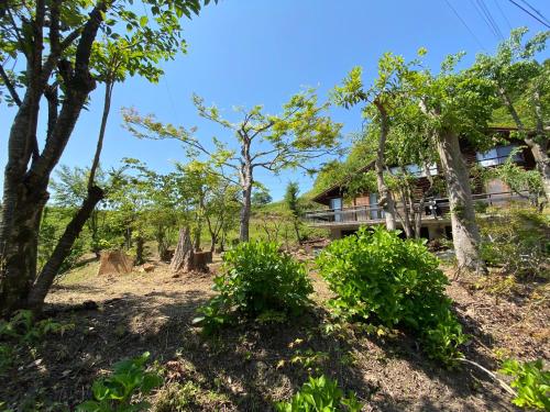 a view of the house from the trees at kakayama hutte in Muraoka