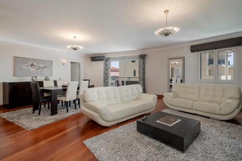 a living room with two white couches and a dining room at Vila Formosa II by An Island Apart in Funchal