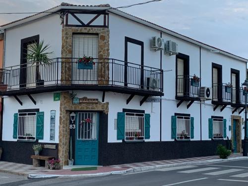 a white building with a green door and balcony at La Casica del Abuelo Valentín 