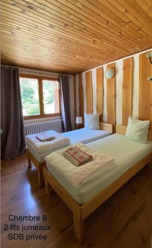 - une chambre avec 2 lits dans une pièce en bois dans l'établissement LE CHAMOIS, à La Poutuire