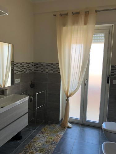 a bathroom with a sink and a toilet and a shower at Casa Renzo in LʼAquila