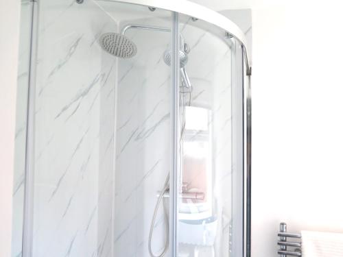 a shower with a glass door in a bathroom at Stoneley Stays by Urban Hazelnut in Crewe
