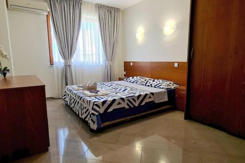 a bedroom with a bed with a zebra blanket at Seagarden Villa Resort / Villa Dimar 2C in Lozenets