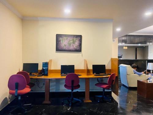 an office with a table with chairs and a laptop at Hotel Diplomat in Cochabamba