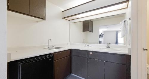 a bathroom with two sinks and a mirror at Budget Inn and Suites Stockton Yosemite in Stockton