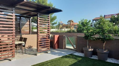 a backyard with a wooden pergola and a table at La Dolce Vita Apartments Unit 2 in Posedarje