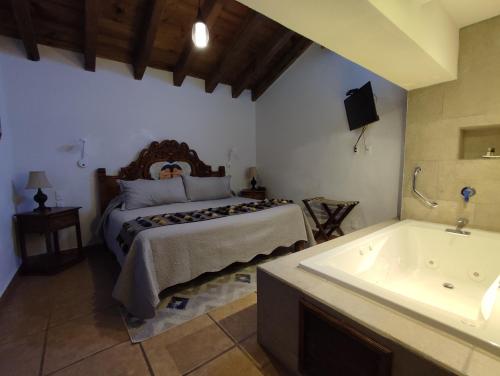 a bedroom with a bed and a bath tub at Hotel Grand Maria in San Cristóbal de Las Casas