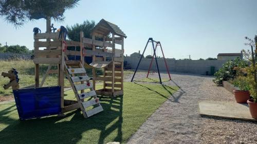 a playground with a slide and a swing at La Dolce Vita Apartments Unit 2 in Posedarje
