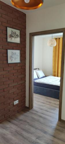 1 dormitorio con cama y pared de ladrillo en Gościniec Mazurek , Apartament Giżycko, en Giżycko