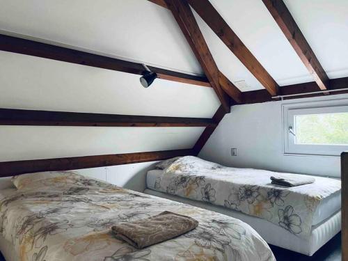 1 dormitorio con 2 camas y ventana en Leuke bungalow in Noord-Holland, en Opmeer