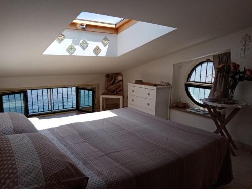 a bedroom with a large bed and a skylight at Rosa dei venti in Scilla