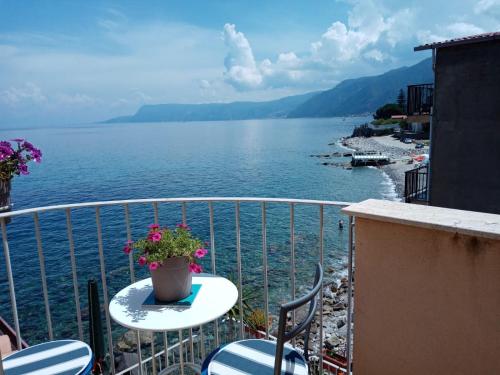 balcón con mesa, sillas y vistas al agua en Rosa dei venti, en Scilla