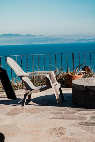 a white chair sitting on a patio near the ocean at Su Casa in Ensenada
