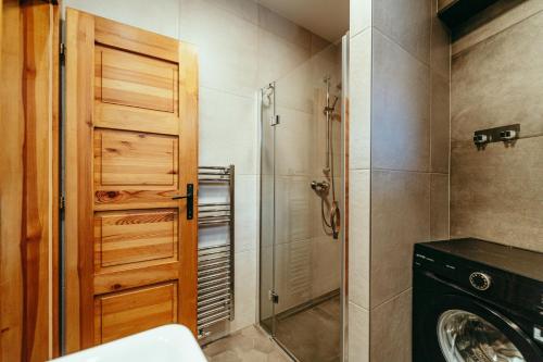y baño con ducha y lavadora. en Luxury style apartment, en Šaštín