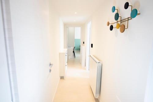 a hallway with white walls and a white stair case at Maison SINDBAD in Pero