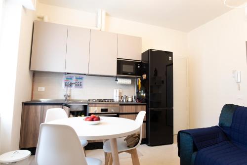 a kitchen with a white table and a black refrigerator at Maison SINDBAD in Pero