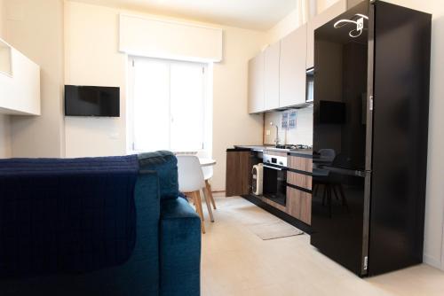 a kitchen with a blue couch and a black refrigerator at Maison SINDBAD in Pero