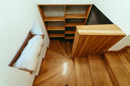 a spiral staircase with wooden floors and wooden shelves at Luxury style apartment in Šaštín
