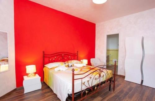 1 dormitorio rojo con 1 cama y pared roja en Da Claudietto, en San Teodoro