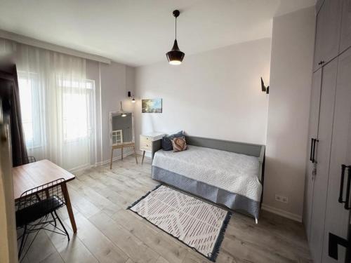 Schlafzimmer mit einem Bett, einem Tisch und einem Fenster in der Unterkunft Stunningly family apartment in Alanya