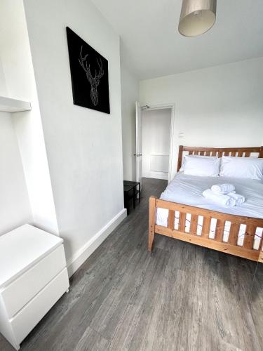 um quarto com uma cama e piso em madeira em Modern 2 bed flat close to Shoreditch / Free Wi-Fi em Londres