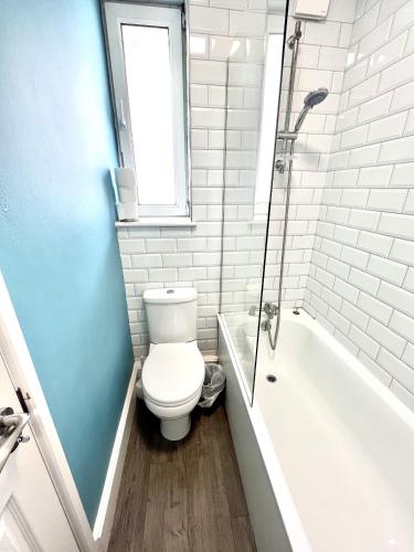 uma casa de banho branca com um WC e uma banheira em Modern 2 bed flat close to Shoreditch / Free Wi-Fi em Londres