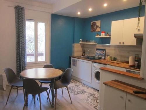 une cuisine avec une table et des chaises dans une pièce dans l'établissement Appart F3 à 150 M de la plage avec parking privé, à Cerbère