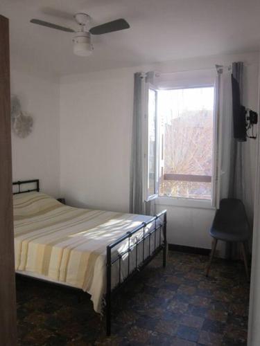 une chambre avec un lit et une fenêtre dans l'établissement Appart F3 à 150 M de la plage avec parking privé, à Cerbère