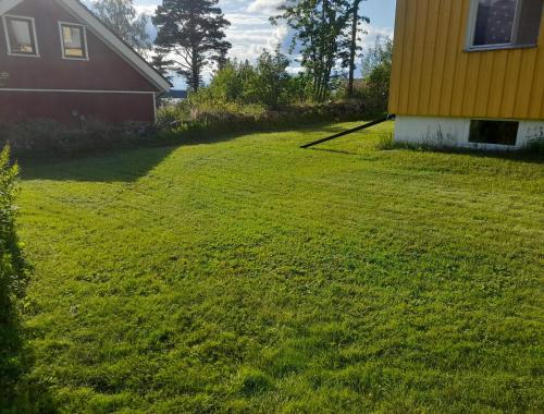 a large yard next to a house and a building at Empty Lots in Camping near Sandbach in Bräcke