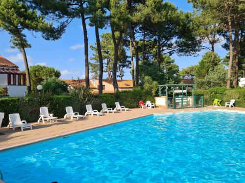 une grande piscine avec des chaises et un gazebo dans l'établissement Résidence avec piscine , Talaris à La Palmyre, aux Mathes