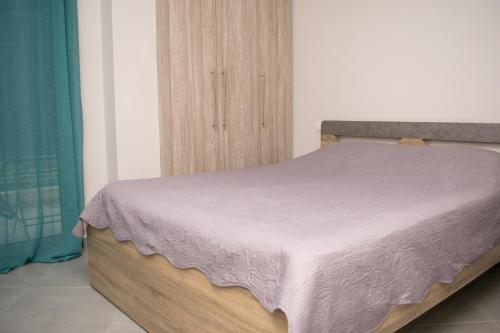 um quarto com uma cama com um cobertor roxo em Angie’s apartment em Kiverion