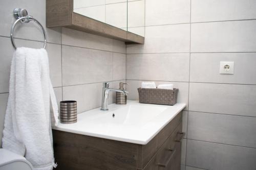 uma casa de banho branca com um lavatório e um espelho em Angie’s apartment em Kiverion