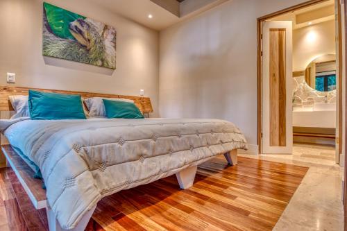 a bedroom with a large bed with blue pillows at The Oasis at Puket in Manzanillo