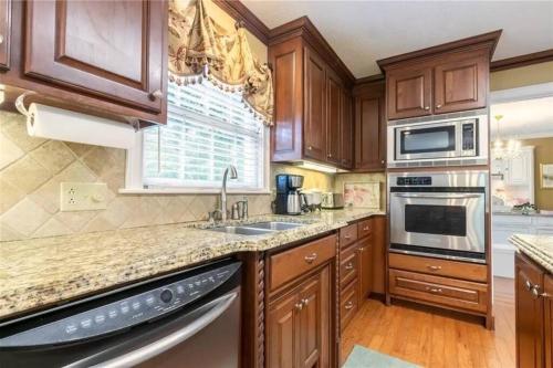 a kitchen with wooden cabinets and a sink at Southern Home and fishing lake. in Gainesville