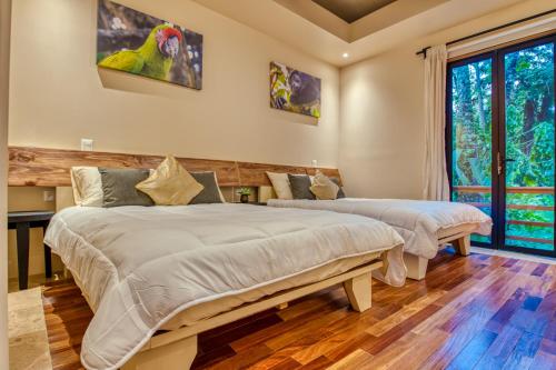 two beds in a room with a parrot on the wall at The Oasis at Puket in Manzanillo