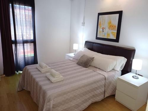 a bedroom with a bed with two towels on it at Ático en el Corazón de Sevilla in Seville