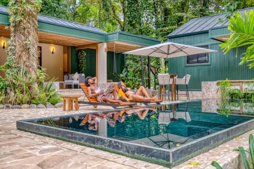 two women laying on a chair next to a swimming pool at The Oasis at Puket in Manzanillo