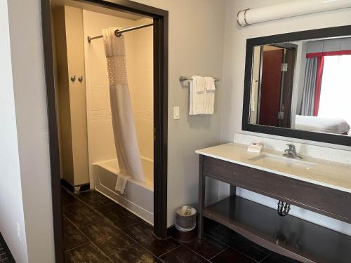 a bathroom with a sink and a tub and a mirror at Studio 6 Suites Pearsall TX in Pearsall