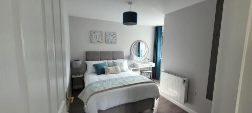 1 dormitorio con cama y escritorio con espejo en Willow Tree Cottage en Ballycastle