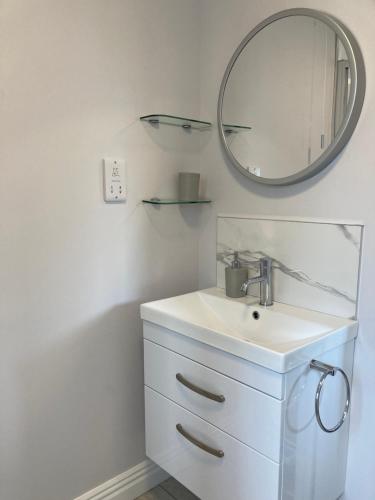a bathroom with a sink and a mirror at Willow Tree Cottage in Ballycastle