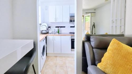 a kitchen and a living room with a couch at Superb One bedroom house in Thamesmead