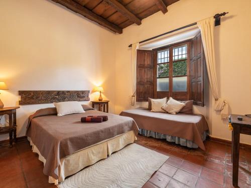 1 dormitorio con 2 camas y ventana en Casita Del Escritor, en Antigua Guatemala