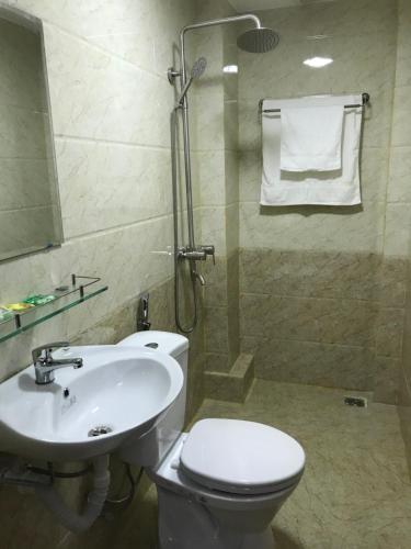 La salle de bains est pourvue de toilettes, d'un lavabo et d'une douche. dans l'établissement Rose, à Hue