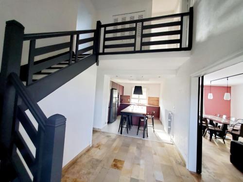 a living room with a staircase and a dining room at Gîte de la valleuse, capacité 12 personnes, idéal pour une grande famille in Senneville-sur-Fécamp