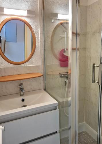 une salle de bain avec un lavabo et un miroir dans l'établissement Résidence avec piscine , Talaris à La Palmyre, aux Mathes