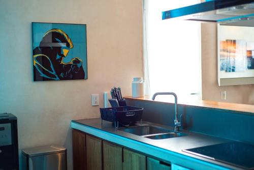 a kitchen with a sink and a painting on the wall at Apartamento en el corazón de Playa del Carmen, Sabor a Miel in Playa del Carmen