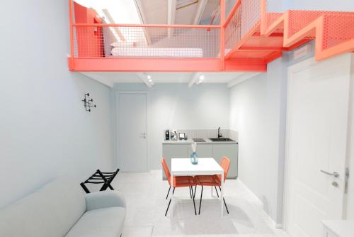 un soggiorno con tavolo e scala rossa di Il Timbro - Dimore Diffuse a Vasto