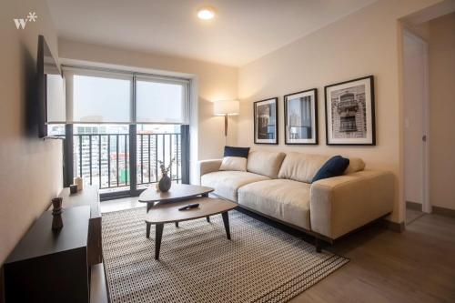 a living room with a couch and a table at Alta by Wynwood House in Lima