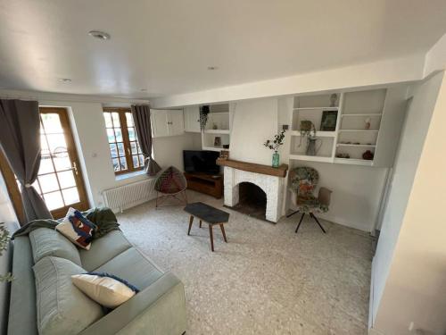 uma sala de estar com um sofá e uma lareira em Location de maison Au fil de l O la Bouille em La Bouille