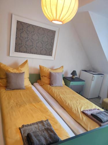 two beds in a attic room with a chandelier at Mosel Boutique in Bruttig-Fankel